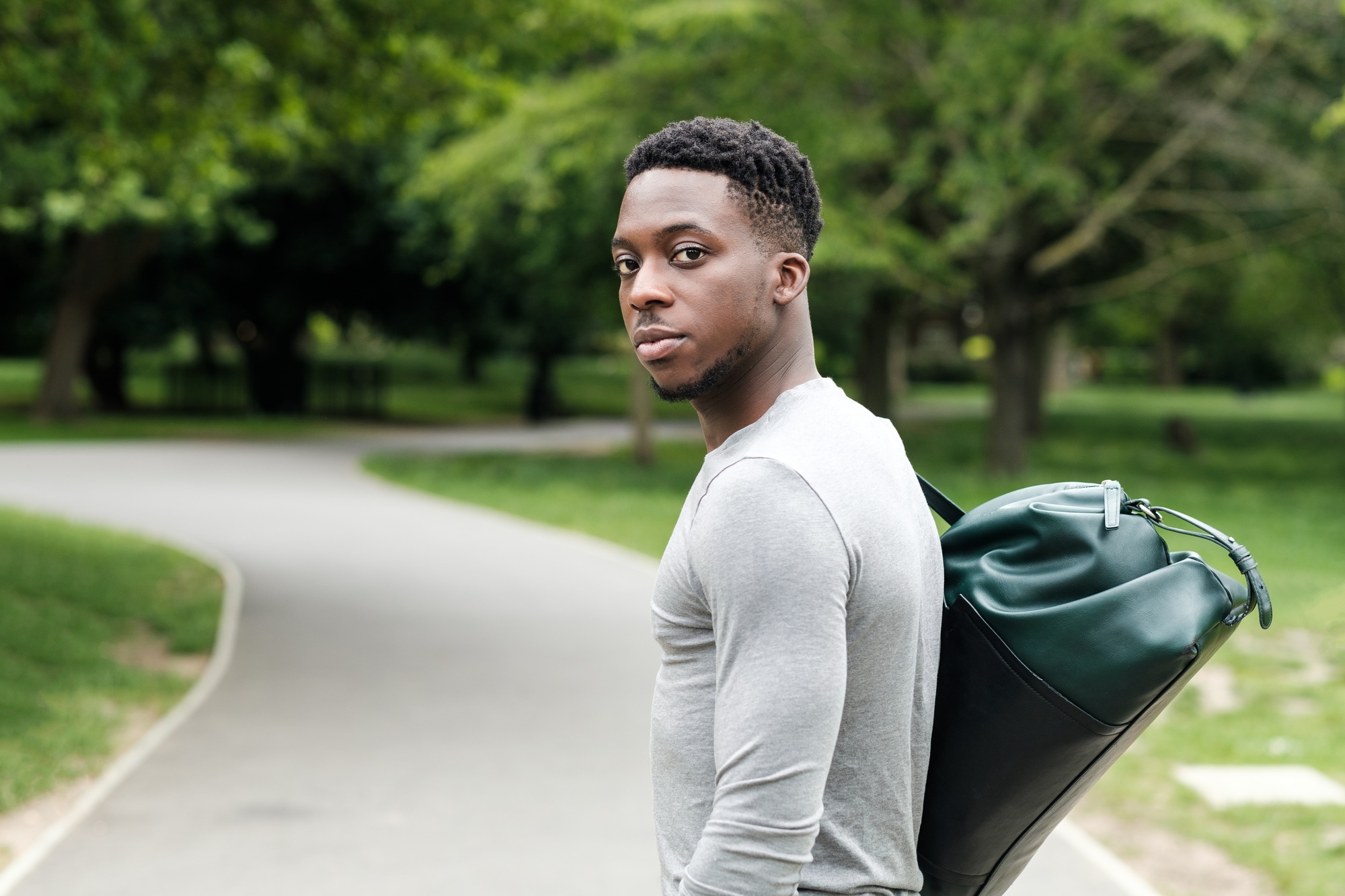 Fit young black man going to training with gym bag.